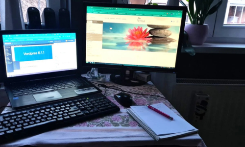 Radni prostor: 2 računara na stolu, sveska i olovka pored njih.